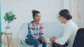 Two women talking in a modern office setting.
