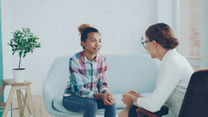 Two women talking in a modern office setting.
