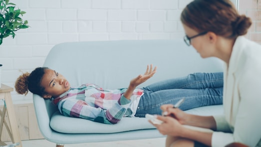 Therapist listens to young woman on couch