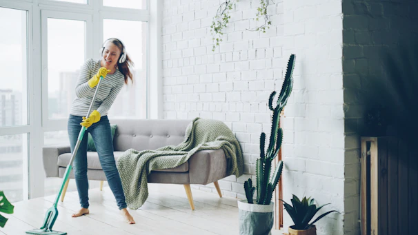 Woman singing and dancing while vacuuming a room