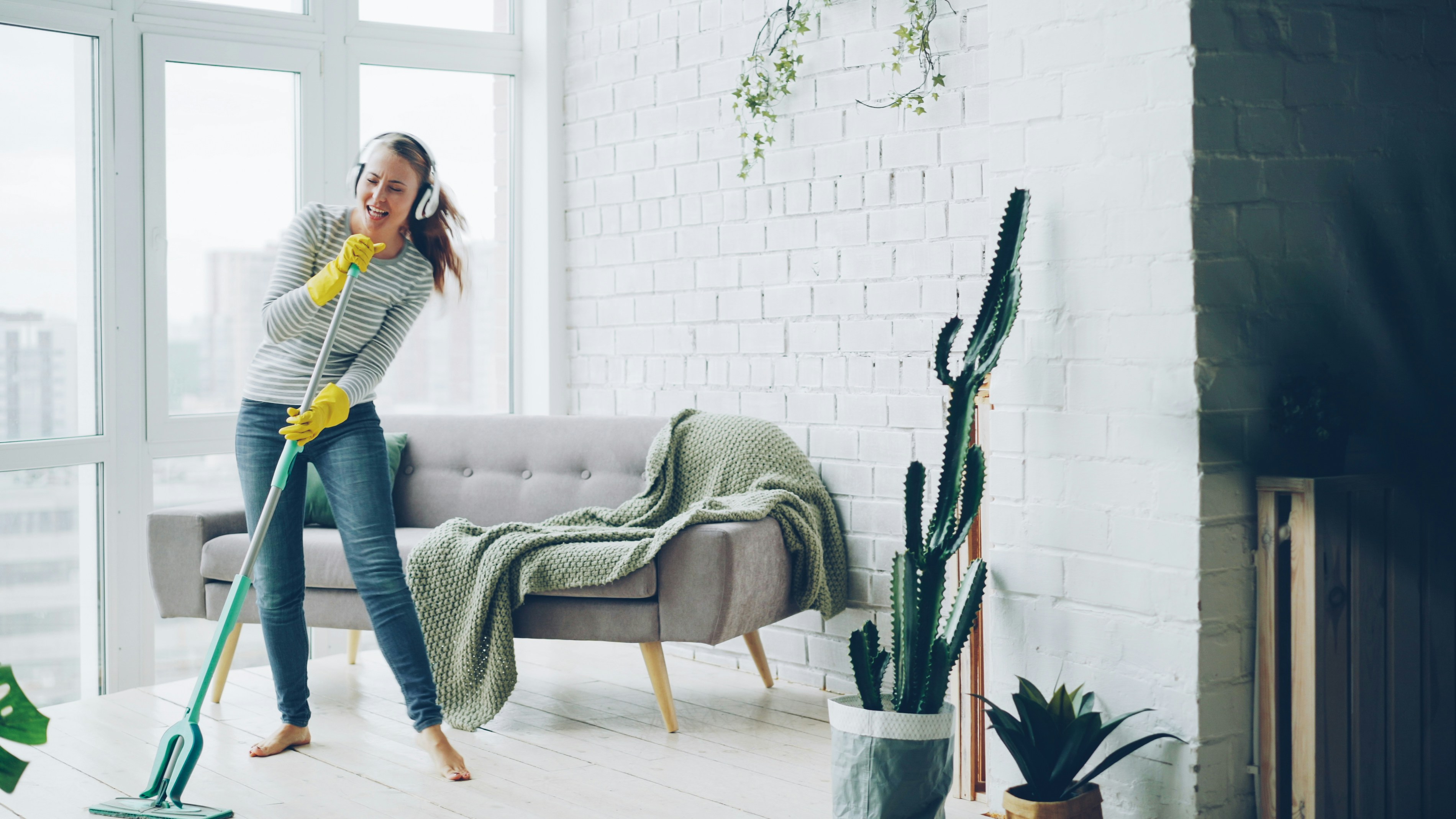 A bright, clean kitchen featuring a glass spray bottle of DIY cleaner, fresh lemons, and a digital tablet showing the EasyHome app.