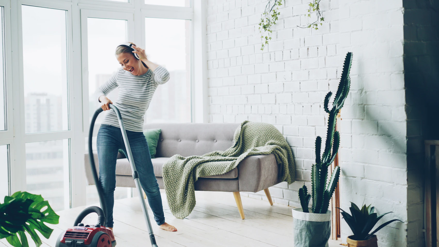 Reinigungskraft in einem hellen, modernen Wohnraum