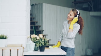 Woman with headphones cleaning and enjoying music.