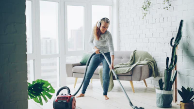Woman vacuuming floor while listening to music.