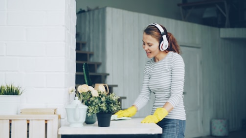 Woman wearing headphones while cleaning