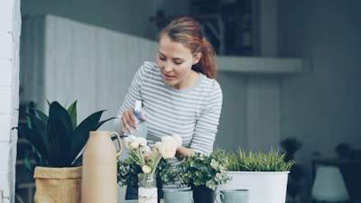 Woman watering plants on a balcony