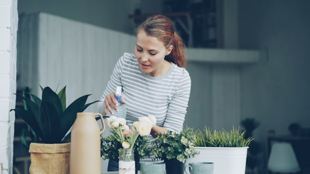 Woman watering plants on a balcony