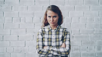 Young woman with arms crossed looks annoyed.