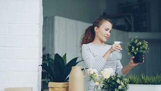 Woman watering plants on a balcony