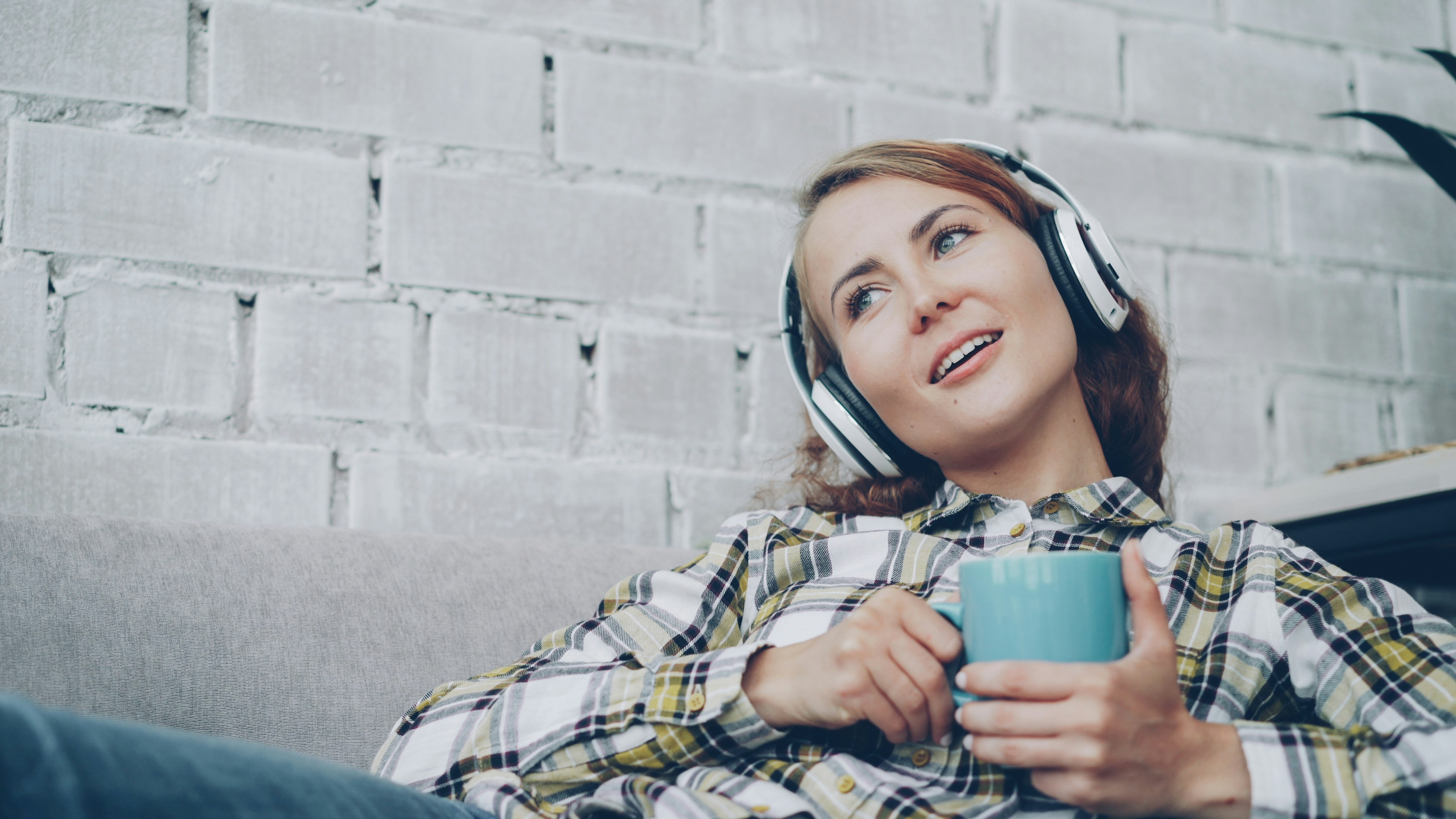 Woman wearing headphones while learning English with a happy and engaged expression