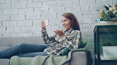 Young woman video calling on a couch