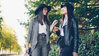 Two women wearing hats talking outdoors