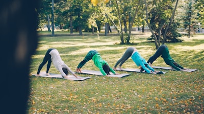 Four people practicing yoga in a park