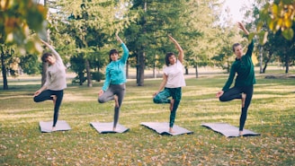 Four people practice yoga in a park.