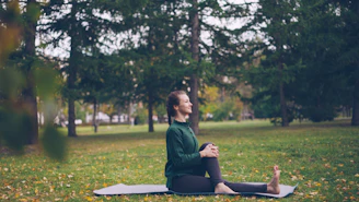 Woman practicing yoga on mat in park