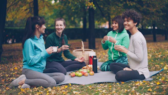 Four friends enjoying a picnic in an autumn park.