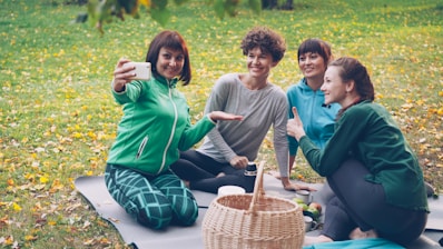 Four friends taking a selfie during a picnic.