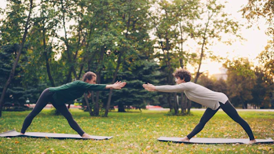 Two people doing yoga in a park