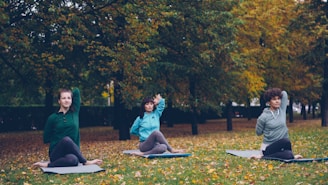 Three women practicing yoga outdoors in autumn