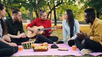 Friends enjoying a picnic and music in the park.