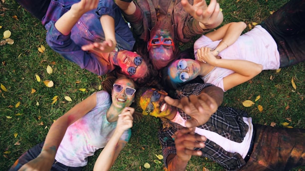 Friends with colorful powder celebrating together outdoors