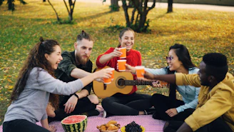 Friends enjoying a picnic and toasting drinks outdoors
