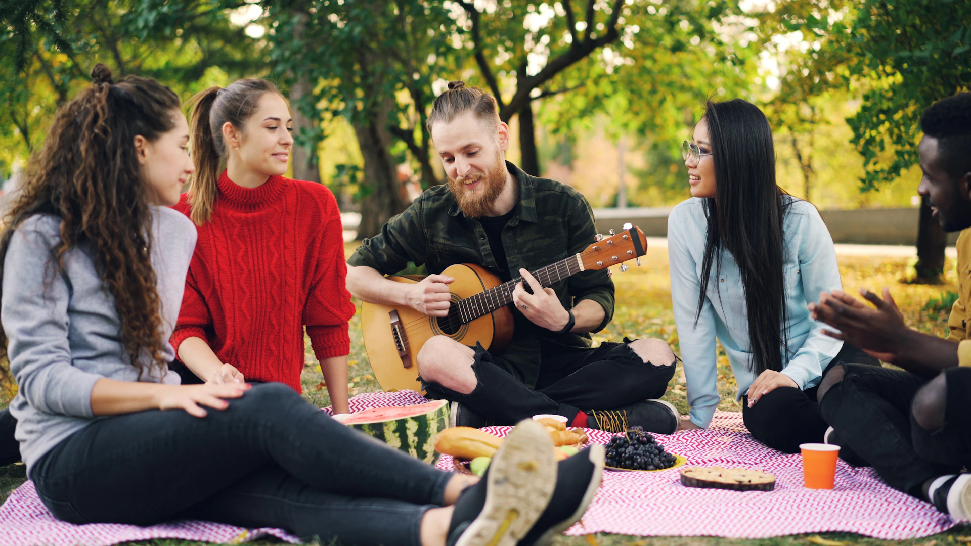 Friends enjoying a picnic and music in the park