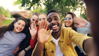 Group of diverse friends waving hello outdoors