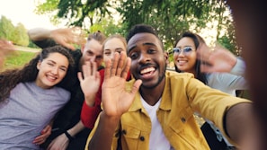 Group of diverse friends waving hello outdoors