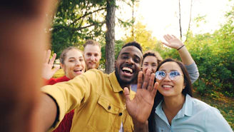 Group of friends waving and smiling outdoors