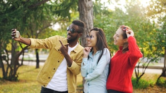 Three friends taking a selfie in a park.