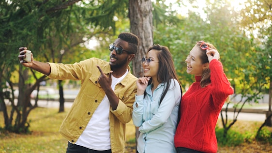Three friends taking a selfie in a park.