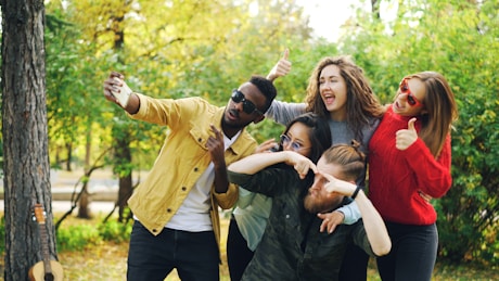 Group of friends taking a selfie in a park.