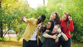 Group of friends taking a selfie in a park.