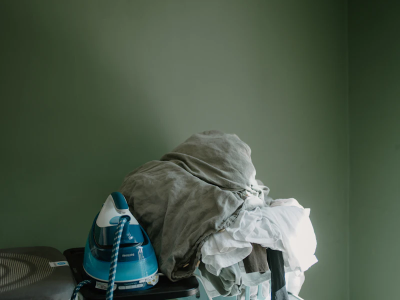 Fresh clothes and iron arranged on an ironing board