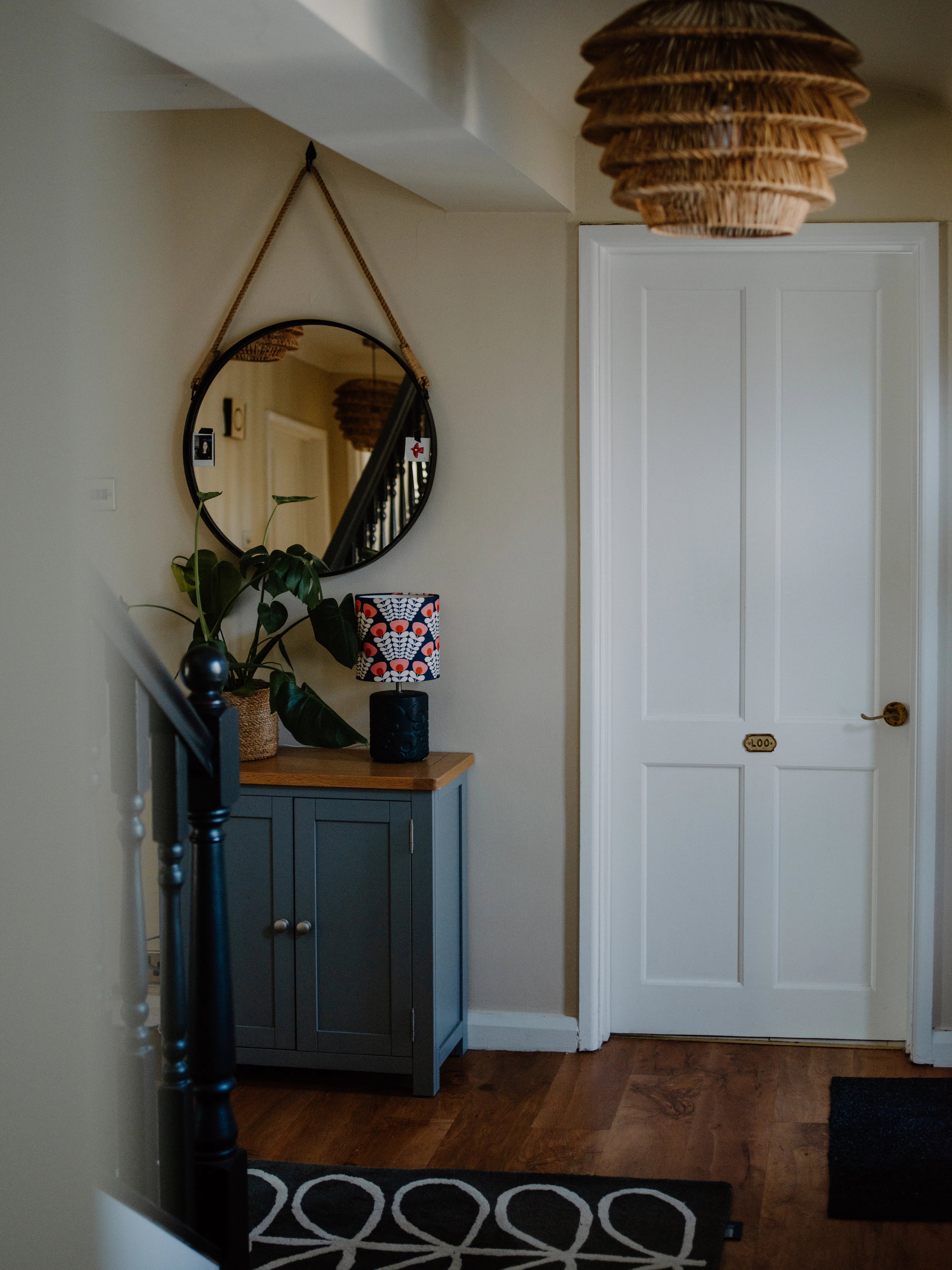 Hallway with a round mirror and cabinet