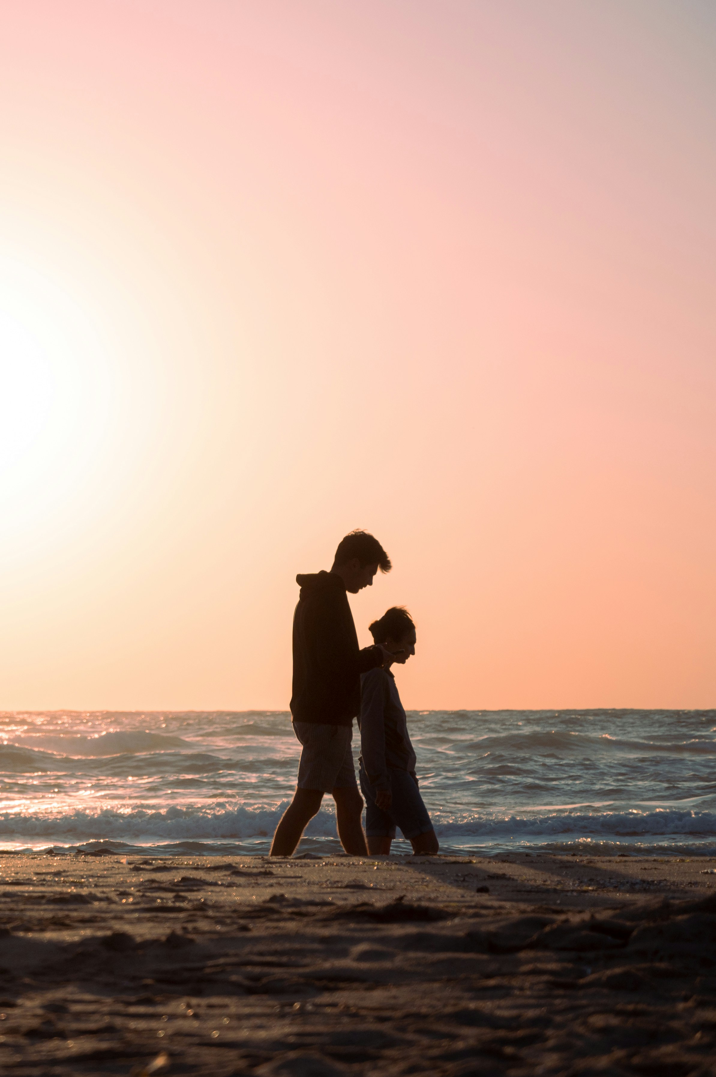 Two people walk on a beach at sunset. photo – Free Sea Image on Unsplash, image size:3000x4508
