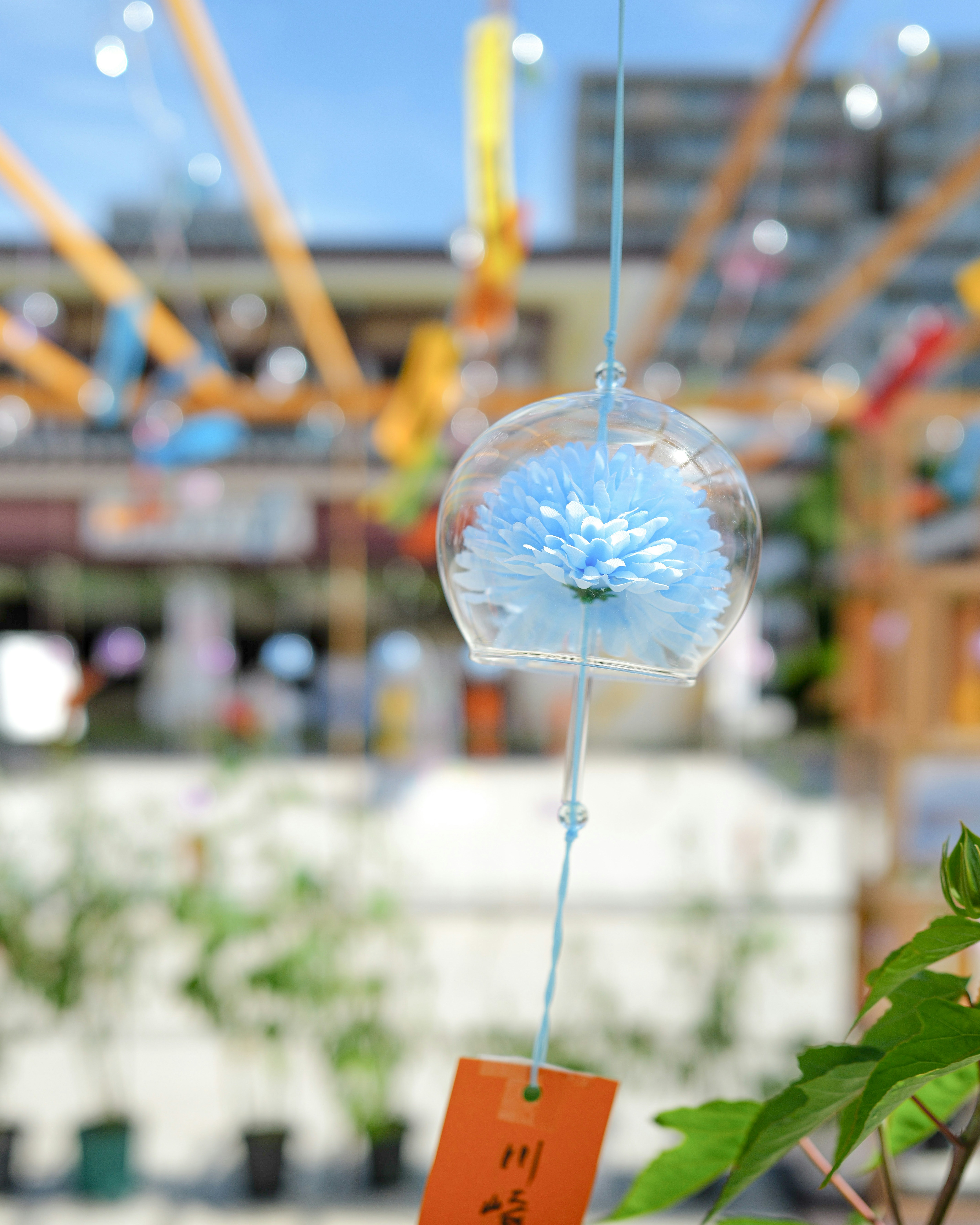 Glass wind chime with blue flower and paper tag