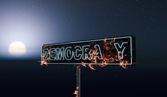 Street sign for democracy burning at night