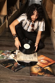 Man with curly hair holding vinyl records