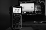Digital multimeter displays zero in front of computer screen