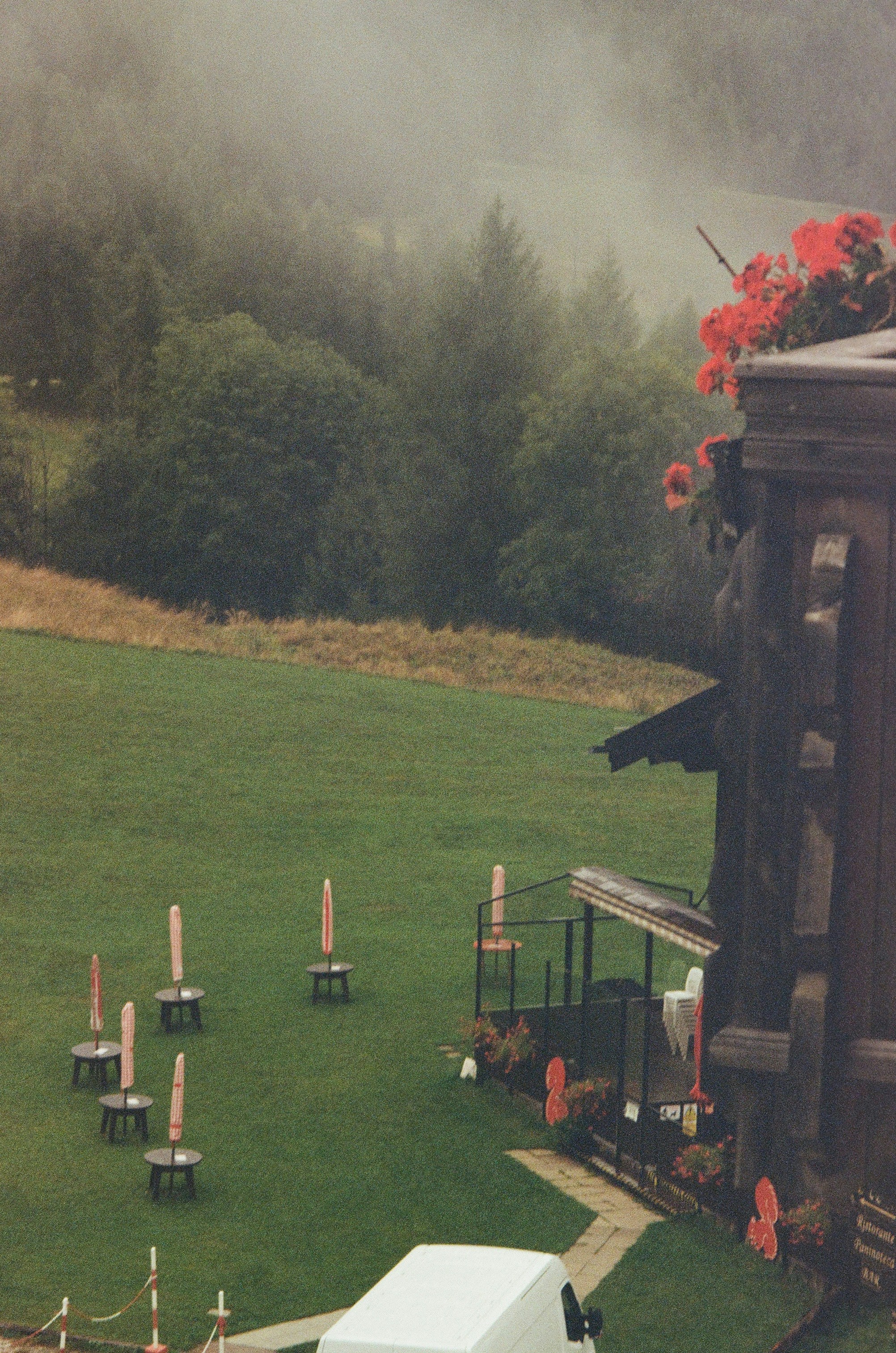 Outdoor seating area with umbrellas on grassy hill.
