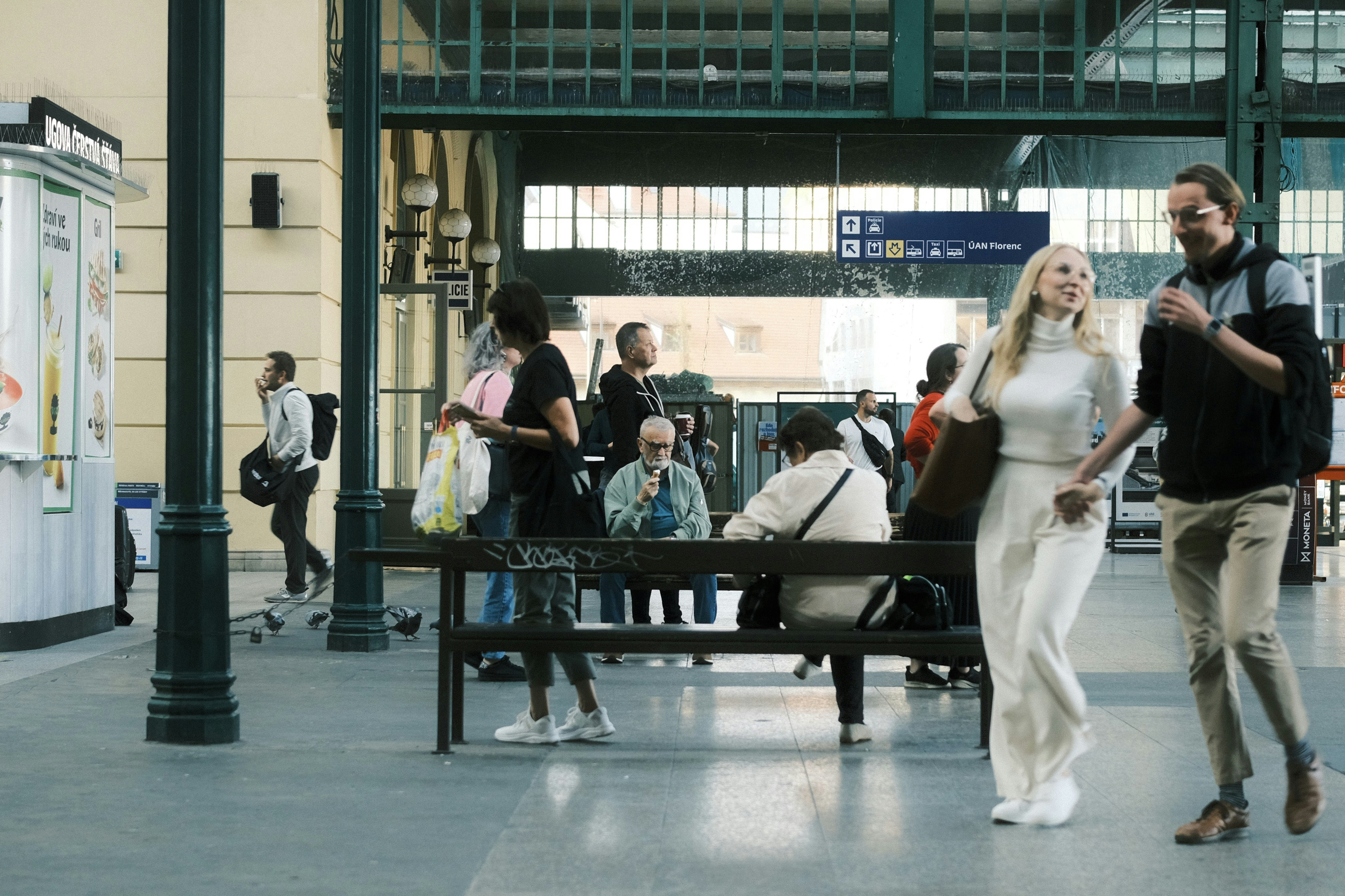 People walking through a train station concourse.