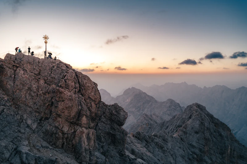 People standing on a mountain summit at dusk