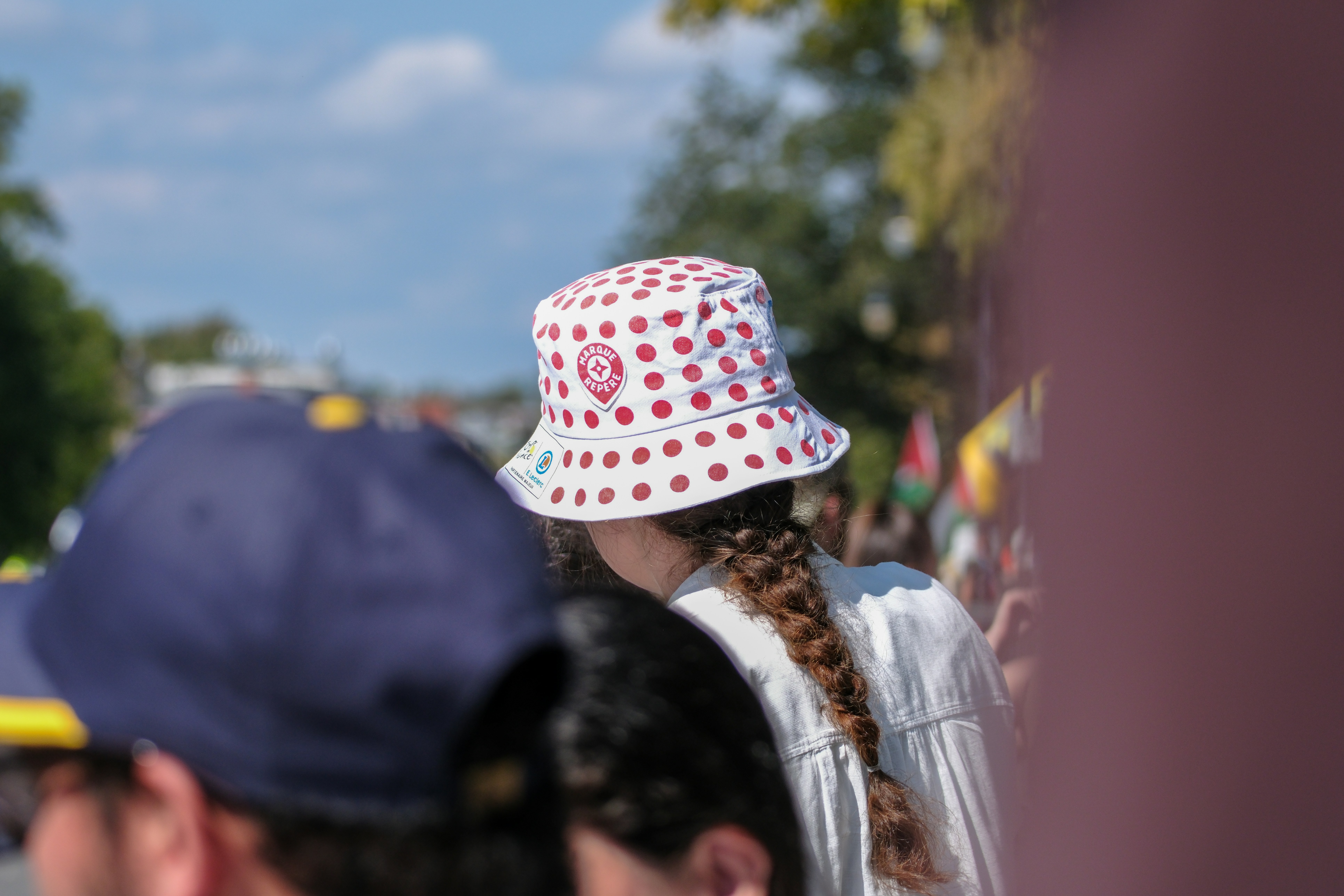 Person wearing a white bucket hat with red dots.