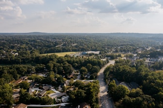 Aerial view of suburban neighborhood surrounded by lush green trees.