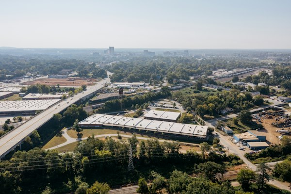 Vista aérea de naves industriales junto a una carretera entre árboles, escenario de la agencia SEO para empresas B2B en México