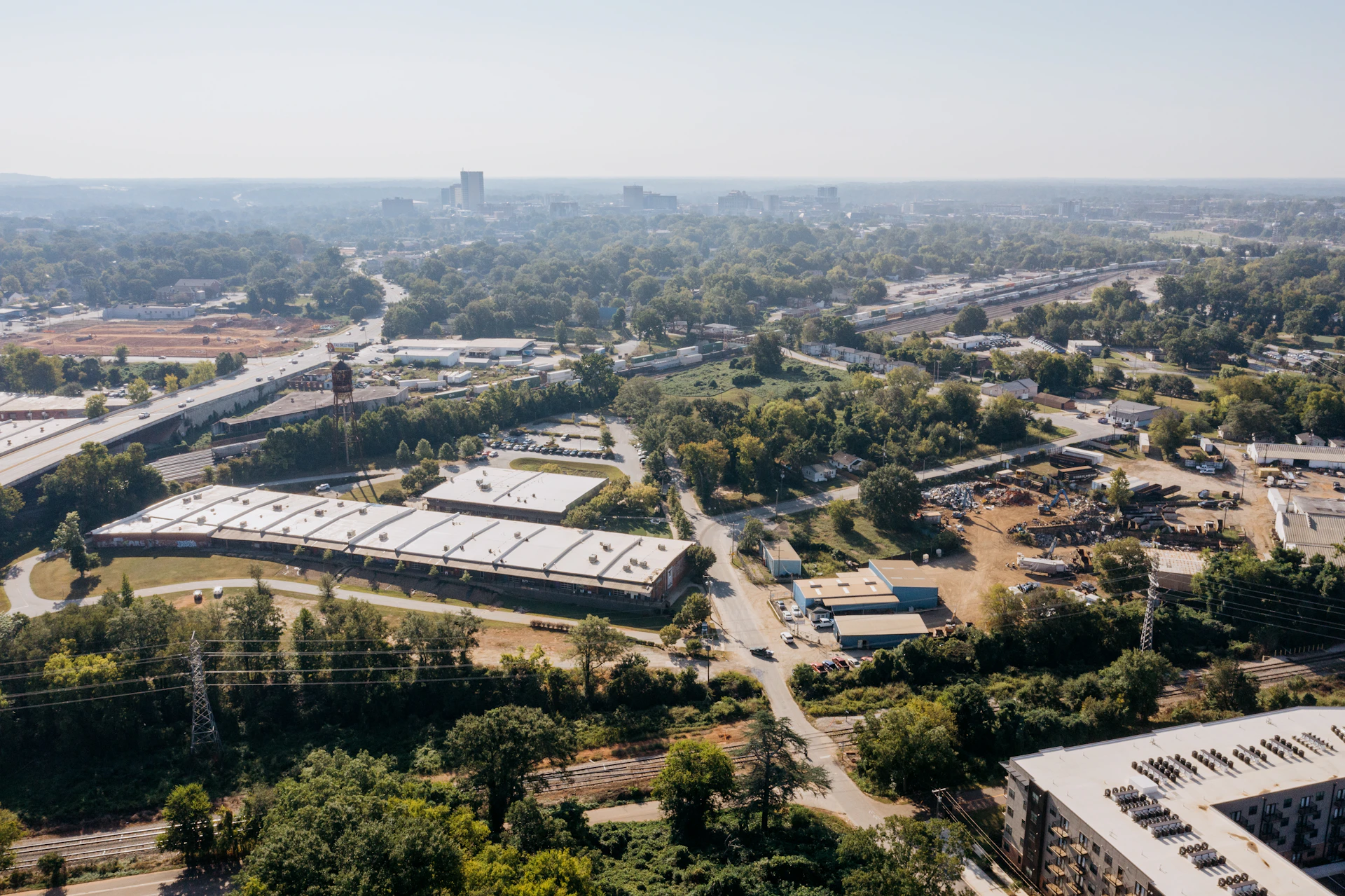 Aerial view of suburban buildings and trees under clear sky.