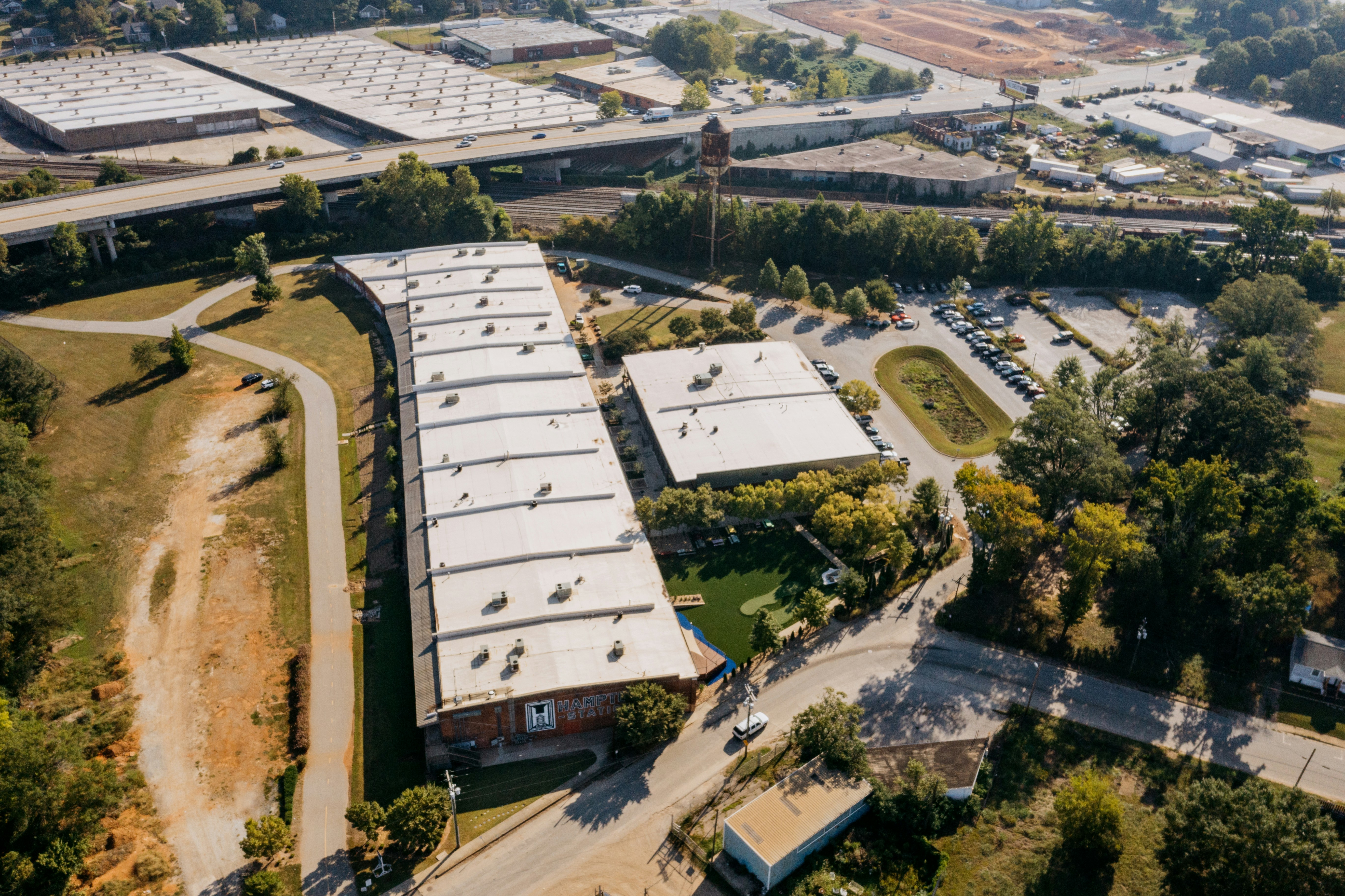 Aerial view of a long industrial building and parking lot.