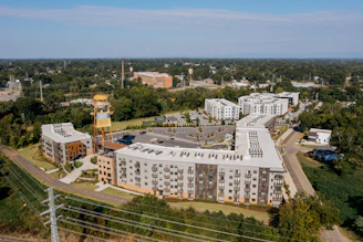 Modern apartment buildings surrounded by trees and greenery.